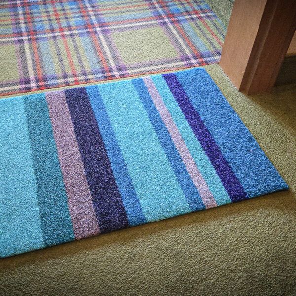 Foto einer Design-Fußmatte mit Streifenmuster. Mit Rand. Farbe Blau. Made in Germany.
