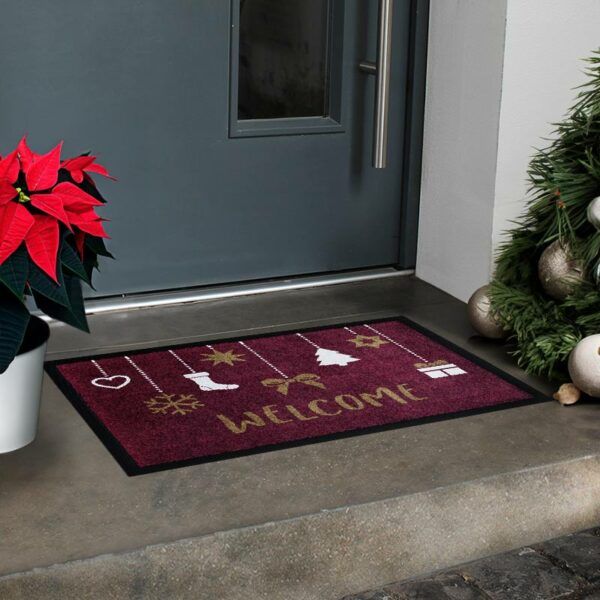 Beispielbild einer Glücksmatte-Fußmatte mit Geschenken und Text "Welcome" auf Rot