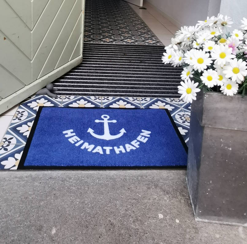 Blaue Fußmatte mit Aufdruck Heimathafen und Anker in weiß