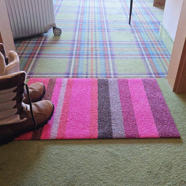 Foto einer Design-Fußmatte mit Streifenmuster. Mit Rand. Farbe Rosa und Rot. Made in Germany.