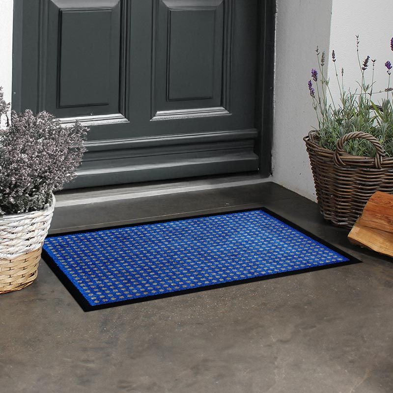 Schwarze Fußmatte mit vielen kleinen beigen Punkten in Blau. Beispielbild.