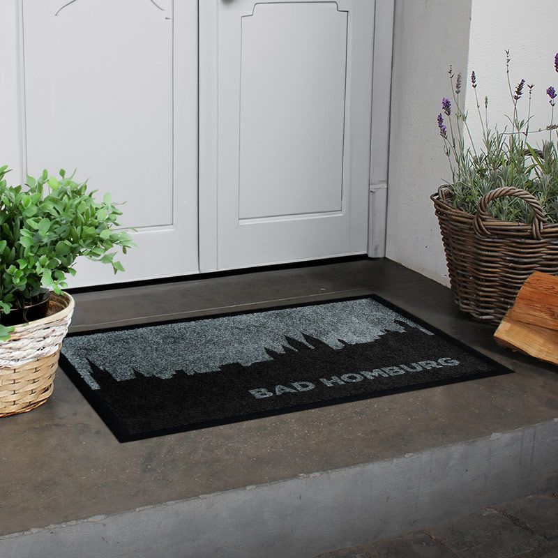 Waschbare Fußmatte von Glücksmatte mit der Skyline von Bad Homburg in Schwarz-Grau. Beispielbild zeigt Matte mit Gummirand.