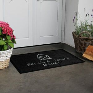 Personalisierte Fußmatte „Kleines Haus“ in Schwarz mit Hausmotiv und Mustertext "Sarah & Jonas Bauer".